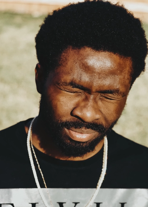 Homme barbu plissant les yeux face au soleil