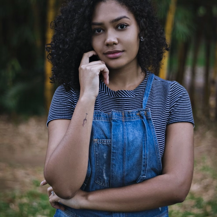 Jeune femmeen salopette en jean posant en extérieur